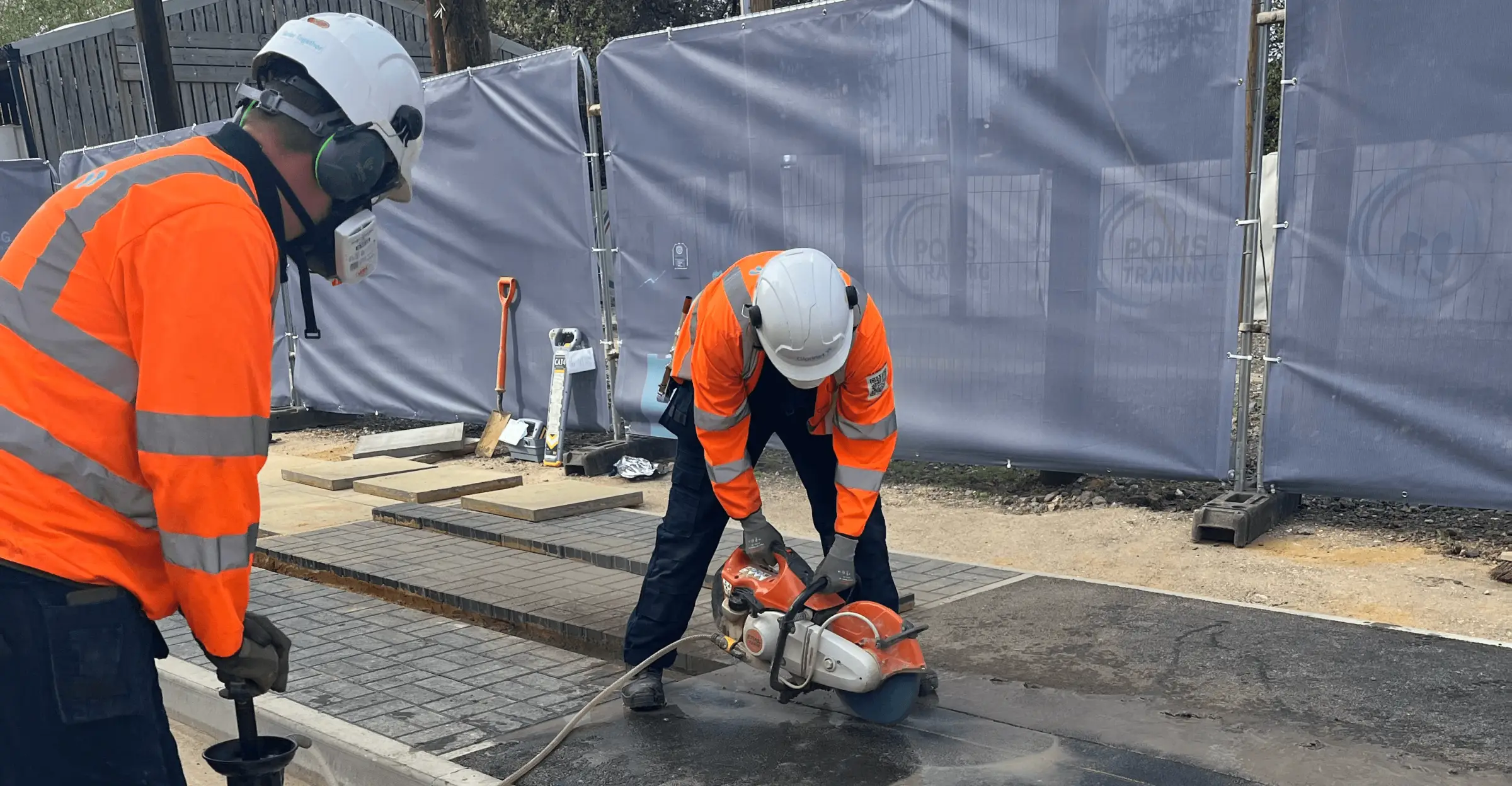 Field engineers in hard hats and hi-vis carrying out fibre street works